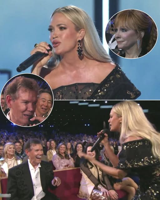 As thousands watched with tear-filled eyes—Reba McEntire among them, following from afar—Carrie Underwood created a moment of pure magic at Opry 100 – A Live Celebration. In a deeply emotional tribute to Randy Travis, she poured her heart into every note, filling the room with nostalgia and admiration. Then came the moment no one expected—Carrie stepped down from the stage, walked toward the front row, and with deep reverence, knelt before Randy Travis, offering him the mic. The legend, overcome with emotion, shared in the tribute that was as much his as it was hers. The crowd, already overwhelmed, erupted into a standing ovation, while host Blake Shelton watched with reverence, visibly moved by the scene. More than just a performance, this was a moment of legacy, gratitude, and a powerful reminder of the bonds that make country music timeless…